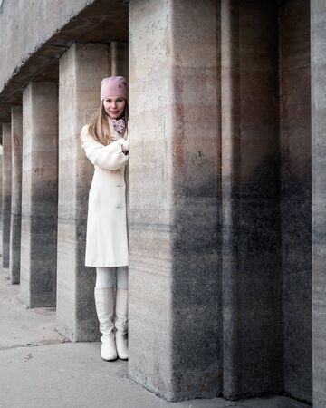 Smiling young woman outdoors next to the wallの写真素材