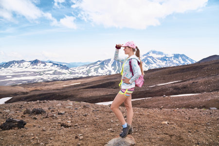 Young woman hiking to the top of the volcano. Kamchatka peninsula, Russia