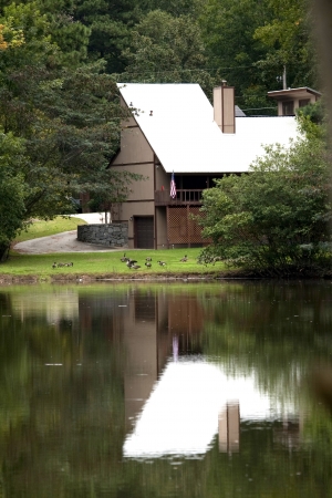 House with white roof reflected in lake の写真素材