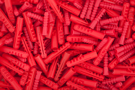 Red plastic dowels for concrete wallの写真素材
