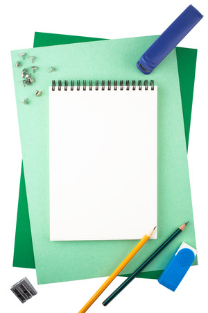 Office accessories on white background: a notebook, sheets of textured paper, pushpins, a stapler, an eraser, pencils and a sharpener.の写真素材