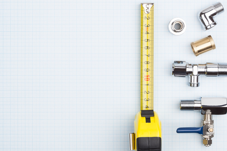 Plumbing supplies on top of graph paper.の写真素材