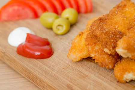 Fried chicken nuggets and sauce, isolated on woodの写真素材