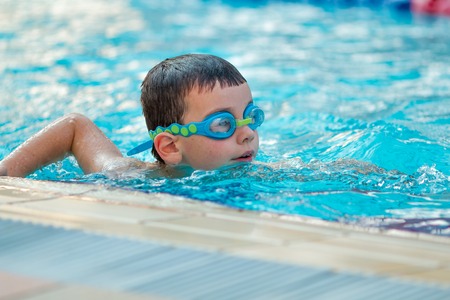 Close up of young boy swimming in pool.の写真素材