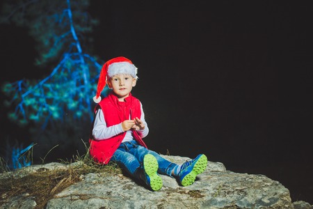 Portrait of friendly family in Santa caps looking at camera on Christmas eveningの写真素材