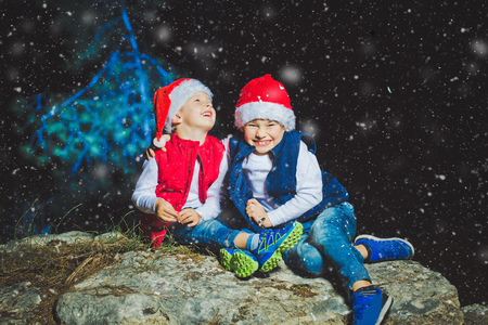 Portrait of friendly family in Santa caps looking at camera on Christmas eveningの写真素材