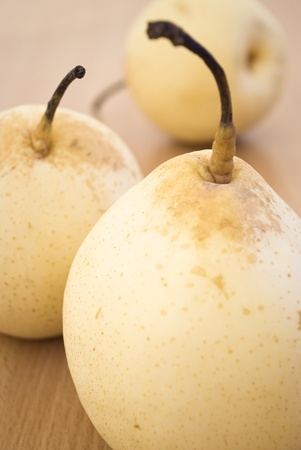 three delicious pears on a table (shallow focus)の写真素材