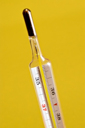 Closeup of medical thermometer on yellow backgroundの写真素材