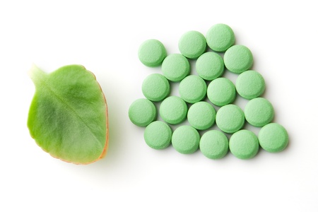 Green leaf and pills on white backgroundの写真素材