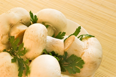 white mushrooms and parsley in bowl on bamboo boardの写真素材
