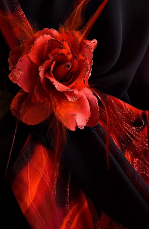 red rose made of fabric and feathers on black night dressの写真素材