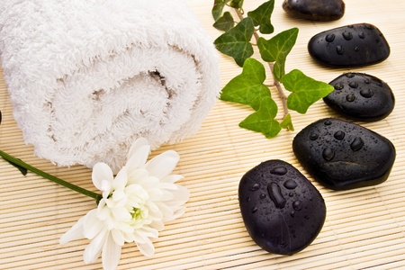 white flower towel ivy and spa stones on bamboo boardの写真素材