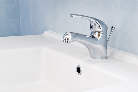faucet on white sink in bathroomの写真素材