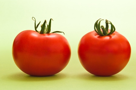 two fresh tomatoes on green backgroundの写真素材