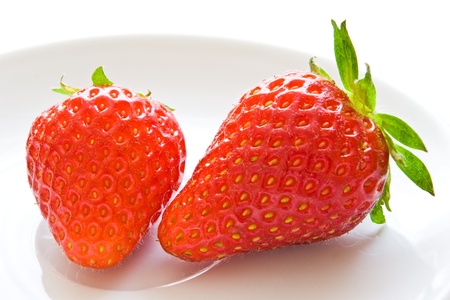 two strawberries on white dishの写真素材