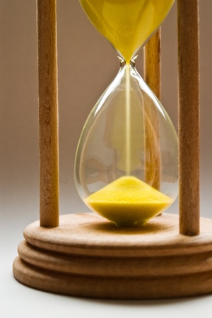 hourglass with yellow sand and shallow depth of field hourglass with yellow sand and shallow depth of field