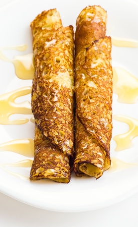 two crepes with honey on white plateの写真素材