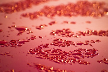 water droplets on red surface with shallow depth of fieldの写真素材