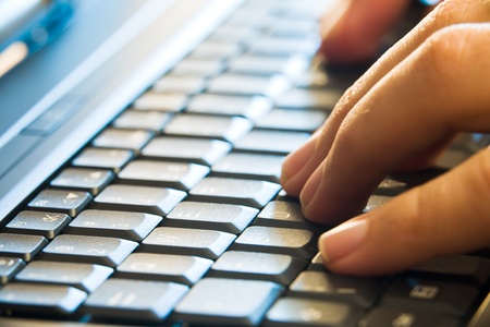 man hands typing on laptop keyboardの写真素材