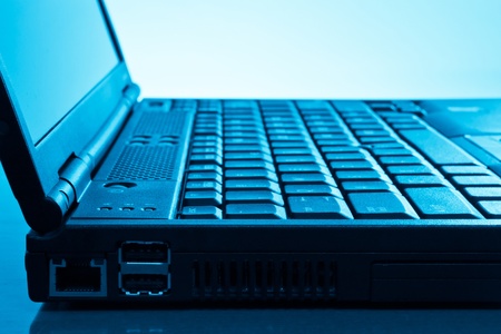 side view of modern laptop - blue toned