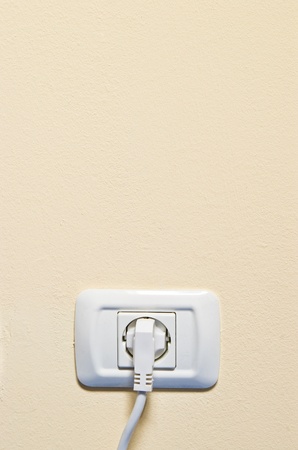 electric consumption - one socket on beige wallの写真素材