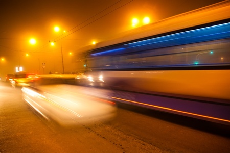 rush of foggy night time traffic on road with automobile light trailsの写真素材