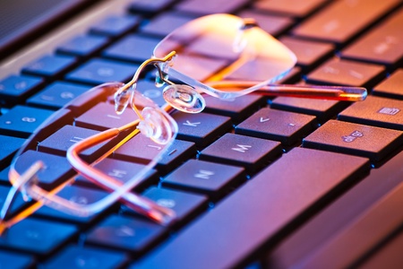 closeup of eyeglasses on laptop keyboardの写真素材