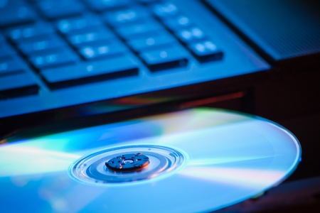 closeup of DVD on laptop in blue lightの写真素材