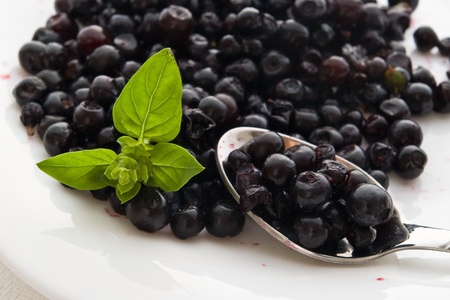 closeup of blueberries and basil on spoon and plateの写真素材