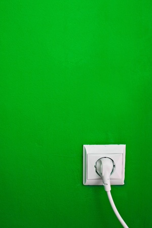 electric consumption - electric outlet on green wallの写真素材