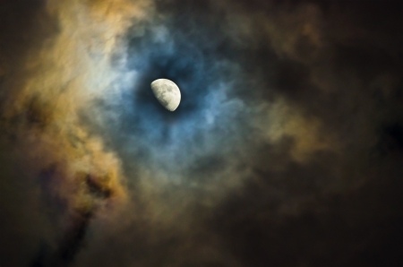 half moon and dramatic colored cloudsの写真素材