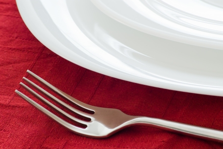 white plates and for on dark red table clothの写真素材