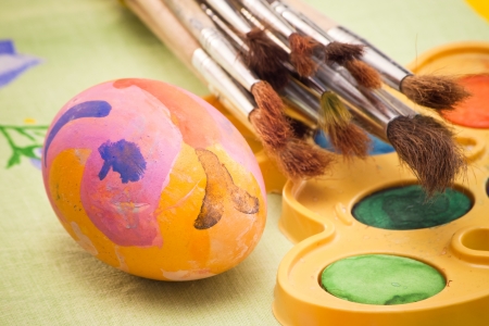 closeup with painted egg and paintbrushesの写真素材