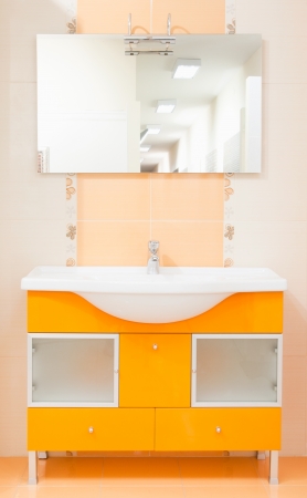 bathroom with peach color furniture sink and mirrorの写真素材