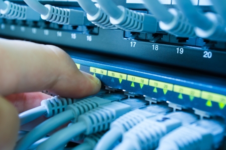hand plugging or unplugging cable in network switch