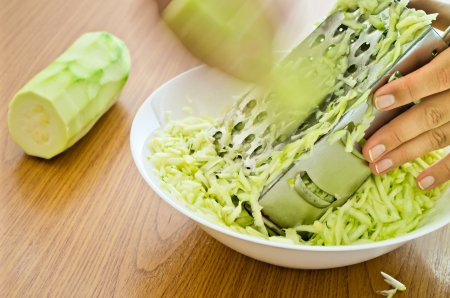 closeup of hands grating fresh zucchiniの写真素材