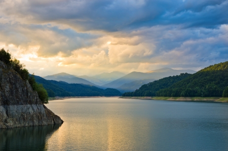 beautiful sunset over mountain lake with cloudy skyの写真素材