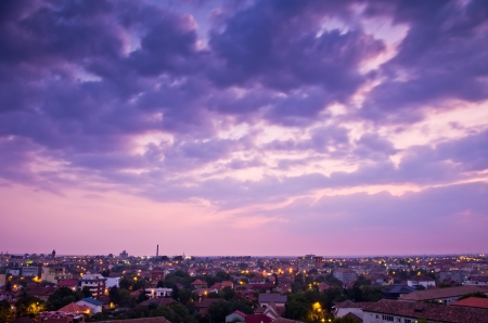 clouds and city with buildings and lights after sunsetの写真素材