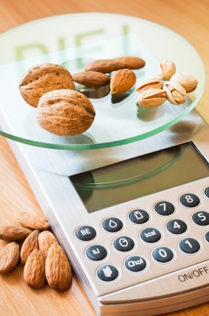 almonds nuts and pistachio on digital kitchen scaleの写真素材