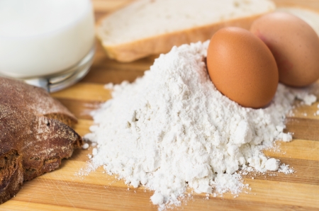 flour and eggs on a wooden boardの写真素材