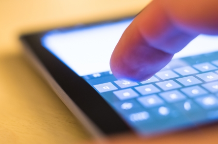 finger touching w on virtual keyboard on tablet-pcの写真素材