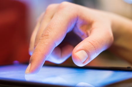 closeup of finger touching tablet-pc screenの写真素材