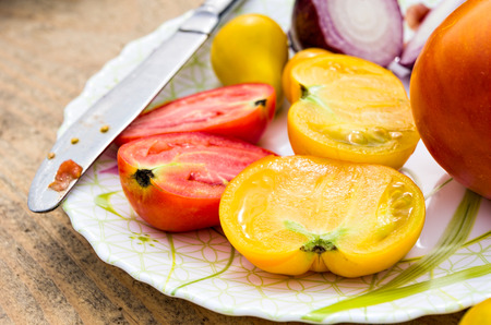 half yellow and red tomatoes on plateの写真素材
