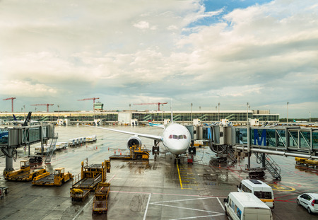 airplane and airport vehicles in beautiful light after rainのeditorial素材