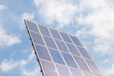 Pole with 20 solar panels collecting sunlight in a blue sky.