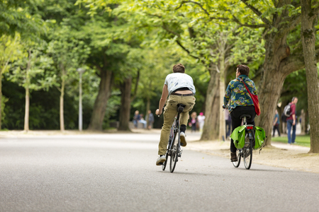 Man and woman biking in the Amsterdam Vondelpark.の写真素材