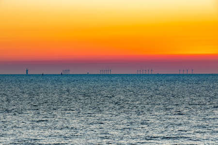 The impressive off shore wind farm Luchterduinen. The windmills are in the North Sea, 23 kilometers from the Dutch coastline between Noordwijk and Zandvoort. On the clear horizon with a beautiful sunset.の写真素材