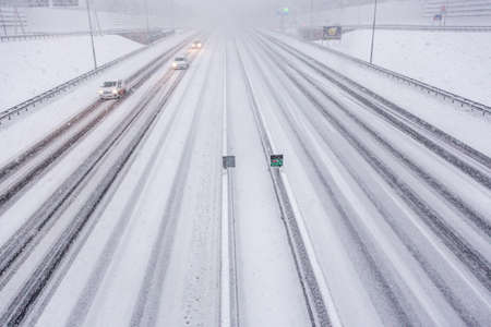 Cars in a heavy snow storm on the A10 highway in Amsterdam on a winter day in december in the Netherlands.の写真素材