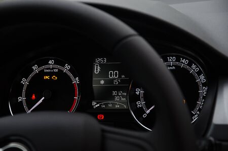Car dashboard with speedometer, tachometer and other indicators. Steering wheel and car devices