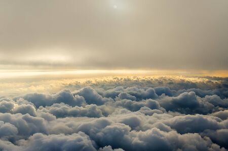 Clouds and sky as seen through window of an aircraft. Flying above the cloudsの写真素材